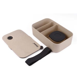 May include: A rectangular beige bento box with a speckled texture, featuring a removable lid with the text Minimal, a black elastic strap, two internal dividers, and a small circular black container with a lid nestled inside the main compartment.