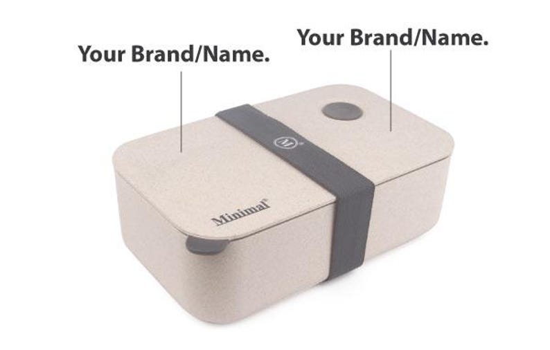 May include: A rectangular beige lunch box with a speckled texture, featuring a dark gray elastic band across the center, a small circular gray vent on the lid, and the word Minimal printed in black on the front edge with Your Brand/Name text labels.