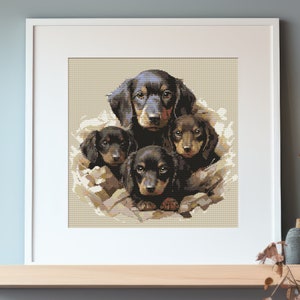 May include: Framed cross-stitch artwork featuring a group of dachshund puppies. The puppies have black and brown fur, with detailed stitching creating a realistic effect. The artwork is set against a neutral background and framed in a white border.
