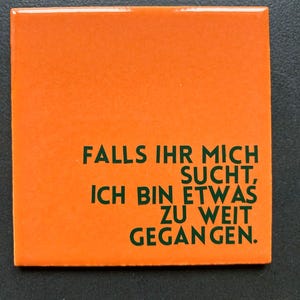 Könnte beinhalten: Ein orangefarbenes Quadrat mit grünem Text, der lautet: "FALLS IHR MICH SUCHT, ICH BIN ETWAS ZU WEIT GEGANGEN."