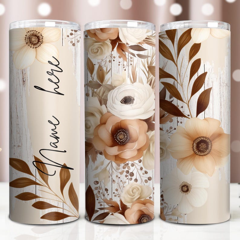 May include: Three stainless steel tumblers with a white woodgrain background and a floral design in shades of brown and cream. The text "Name here" is printed on the left tumbler.