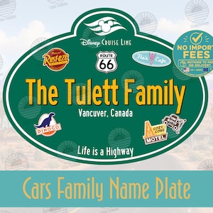 Puede incluir: Un letrero ovalado verde con el logotipo de Disney Cruise Line, un escudo de la Ruta 66 y varios iconos temáticos de Cars, incluyendo Rust-eze, Flo's Cafe, Dinoco y Cozy Cone Motel. El texto dice The Tulett Family, Vancouver, Canada, y Life is a Highway.