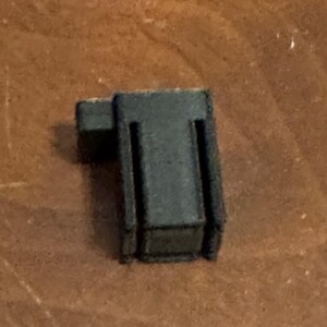 May include: A black plastic door stop with a rectangular shape.