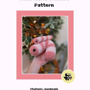 May include: A pink and white crocheted worm toy with black eyes is held in a hand. The image is framed in a pink border, with the text "Basic Worm Crochet Pattern" at the top. The creator's handle, @kailanis_handmade, is at the bottom.