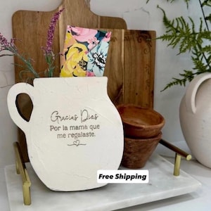 May include: A set of three ceramic mugs with a speckled, matte finish. The mugs are in shades of cream, light gray, and dark gray. Each mug has a simple, minimalist design and a rounded handle.