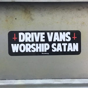 May include: A black and white sticker with the text "DRIVE VANS + WORSHIP SATAN" in white letters. The plus signs are red and the text "Deathrap" is in smaller white letters below the main text.