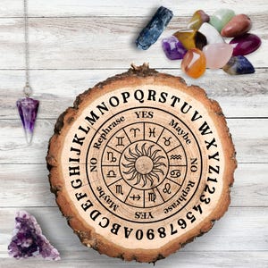 May include: A wooden Ouija board with a circular design featuring the alphabet, numbers, and the words "Yes", "No", "Maybe", and "Rephrase". The board is surrounded by various crystals and a pendulum.