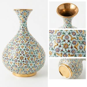 Pu&ograve; includere: Un vaso in ceramica azzurro chiaro con un motivo ripetitivo di piccoli fiori viola, accenti dorati e sottili linee verdi. Il vaso presenta un bordo svasato con interno dorato e una base dorata, che mette in risalto i dettagli floreali.