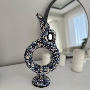 May include: A blue and white ceramic vase with a floral pattern. The vase has a round opening and a base.