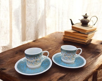 Juego de taza y platillo de espresso de porcelana hechos a mano: pieza de café artesanal con detalles florales azules y dorados.