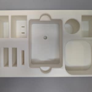 Puede incluir: Bandeja organizadora de pl&aacute;stico blanco con m&uacute;ltiples compartimentos de diferentes tama&ntilde;os. La bandeja tiene un compartimento rectangular grande en el centro, un compartimento rectangular m&aacute;s peque&ntilde;o a la derecha y un compartimento circular en la parte superior derecha. Hay cinco compartimentos rectangulares m&aacute;s peque&ntilde;os en el lado izquierdo de la bandeja.
