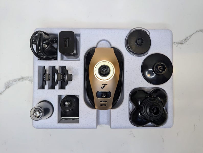 May include: A gold and black electric shaver with multiple attachments, including a nose trimmer, beard trimmer, and hair clippers. The shaver is packaged in a white box with a foam insert.