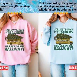 May include: A light pink sweatshirt and a light blue sweatshirt, each featuring a graphic of a yellow school bus carrying a Christmas tree on its roof. The text reads: JOLLIEST BUNCH OF TEACHERS THIS SIDE OF THE HALLWAY! in dark green lettering.