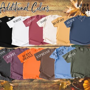 Op de afbeelding: Een verzameling t-shirts met korte mouwen in verschillende kleuren, waaronder zwart, wit, karmozijnrood, ivoor, mosterd, denim, peper, bes, oranje, espresso, washed denim en mos. De tekst "Additional Colors" staat bovenaan.