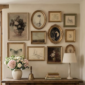 Peut inclure: Une table console en bois supporte un vase en céramique avec des fleurs roses et blanches, une cloche en laiton, des livres intitulés Flora et English Gardens, et une lampe blanche. En dessous, un panier en osier contient un tissu rose.