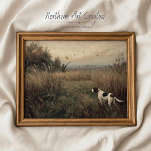 Può includere: Stampa vintage incorniciata con una scena di caccia con un cane in un campo. L'opera raffigura un cacciatore, uccelli in volo e un cane con segni bianchi e neri. La cornice è di colore marrone caldo. Il testo "Northern Art Creative" e "Vintage Aesthetic Prints" è visibile.