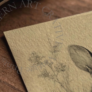 May include: A detailed pencil drawing of a deer's eye and ear, with a focus on the animal's fur texture. The artwork is set against a beige background with delicate plant illustrations. The words "NORTHERN ART CREATIONS" are visible.