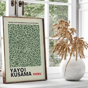May include: A framed print of a green polka dot pattern with the text "MUSEE D'ART MODERNE DE LA VILLE DE PARIS" at the top and "YAYOI KUSAMA 草間彌生" at the bottom.
