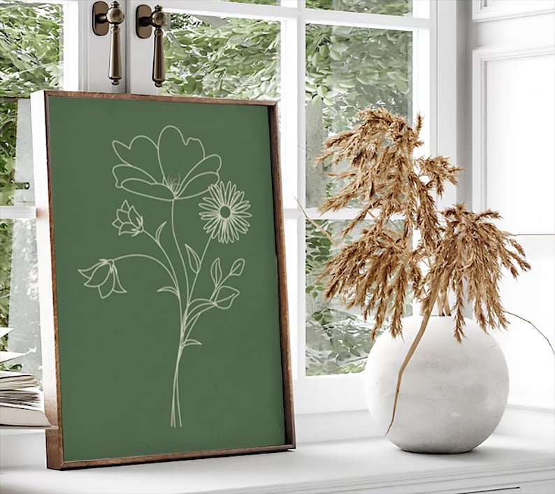May include: A framed print with a green background and a white line drawing of a bouquet of flowers. The flowers include a large bloom, a smaller bell-shaped flower, and a daisy.