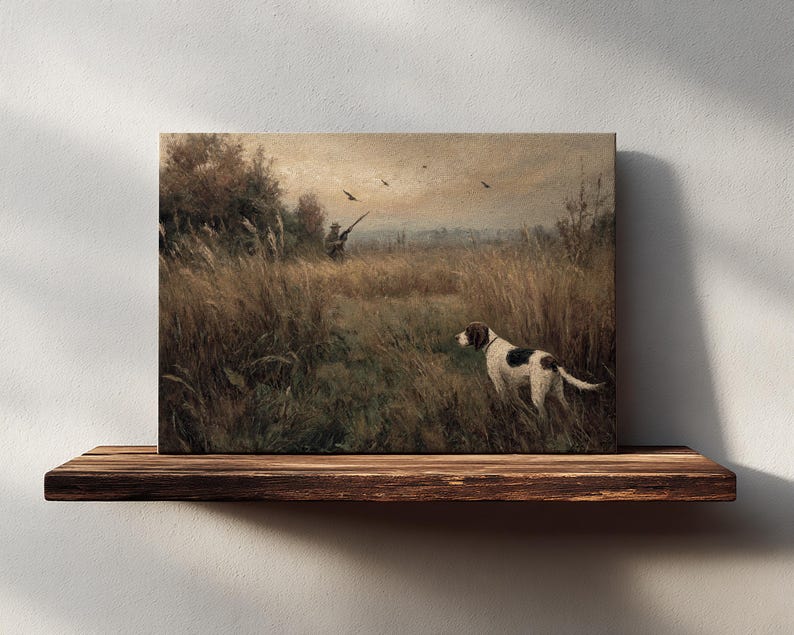 Peut inclure: Impression sur toile d'une sc&egrave;ne de chasse avec un chien dans un champ. Le chien, blanc avec des taches marron, se tient dans les hautes herbes. Un chasseur est visible &agrave; l'arri&egrave;re-plan, visant avec un fusil. Esth&eacute;tique vintage et rustique.