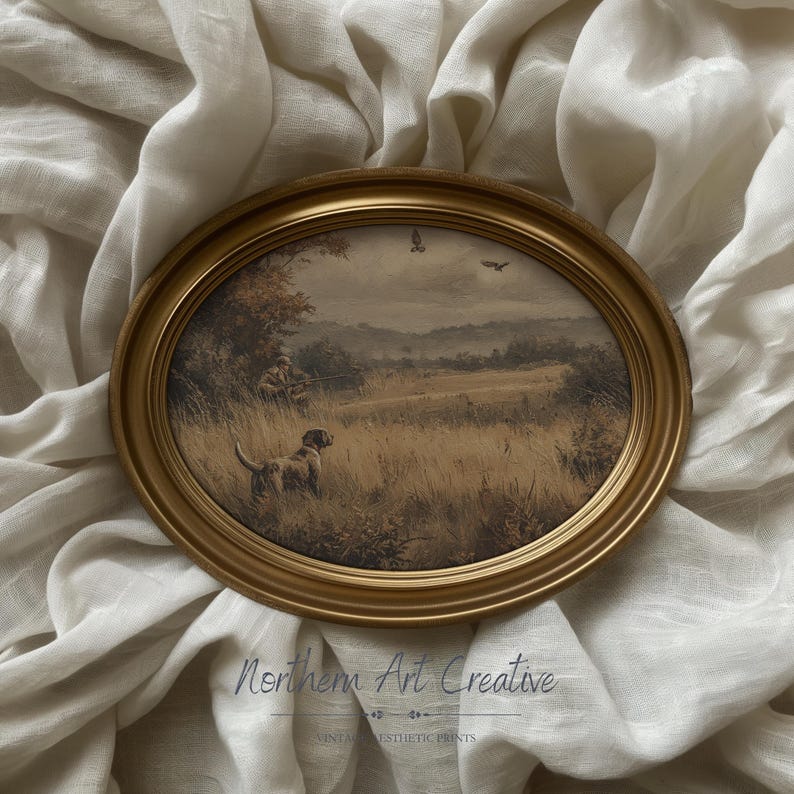 May include: Oval framed print featuring a sepia-toned hunting scene with a dog, hunter, and birds in flight. The gold frame surrounds the artwork, set against a neutral fabric backdrop. The text "Northern Art Creative" is visible at the bottom.