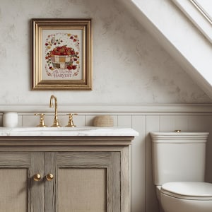 May include: A framed wall art print titled Autumn Harvest featuring a basket of red apples, colorful fall leaves, and a small owl. The artwork is displayed in a gold-toned frame with a decorative border, showcasing a seasonal theme with warm colors.