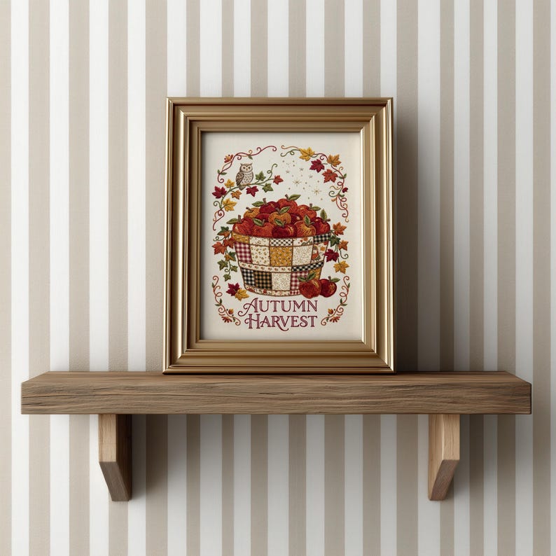 May include: A framed print featuring a basket filled with red apples, surrounded by autumn leaves and a small owl. The text "AUTUMN HARVEST" is printed in red at the bottom. The artwork is enclosed in a metallic gold frame with a classic profile.