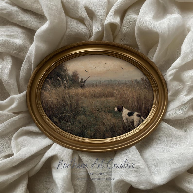 Peut inclure: Impression ovale encadr&eacute;e repr&eacute;sentant une sc&egrave;ne de chasse avec un chien, un chasseur et des oiseaux en vol. L'&oelig;uvre d'art se d&eacute;roule dans un champ avec de hautes herbes et des arbres, encadr&eacute;e par un cadre ovale dor&eacute;. L'impression est pos&eacute;e sur un tissu blanc textur&eacute;.