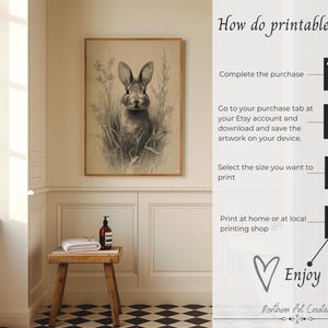 May include: A framed sepia-toned print of a rabbit in a field of tall grass. The artwork hangs on a cream-colored wall. Text on the right side explains how printables work, including steps to purchase, download, and print. The text includes the words "Enjoy" and "Northern Art Creative."