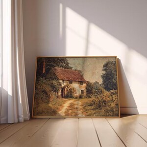 Puede incluir: L&aacute;mina art&iacute;stica vintage enmarcada que representa una pintoresca casa de campo con tejado de tejas rojas y un camino de tierra que conduce a la puerta principal. La obra de arte est&aacute; ambientada en un entorno natural y rural con exuberante vegetaci&oacute;n y &aacute;rboles.
