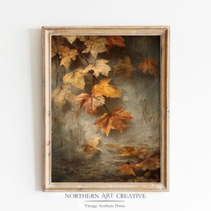 May include: A framed vintage print depicting autumnal leaves in gold, orange, and brown against a textured, muted teal backdrop. The artwork is enclosed in a light-coloured wooden frame. The text "NORTHERN ART CREATIVE" and "Vintage Aesthetic Prints" is visible at the bottom.