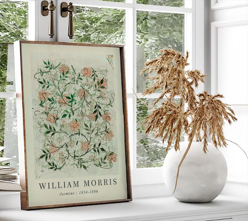 May include: A framed print of a botanical illustration with a white background and green and pink floral designs. The print has the text "William Morris" and "Jasmine | 1834-1896" below the illustration.