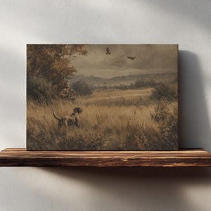 May include: A sepia-toned canvas print depicting a hunting scene. A dog stands in tall grass, with a hunter in the background. Two birds fly overhead. The artwork is displayed on a rustic wooden shelf against a white wall.