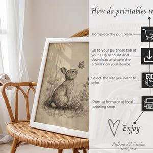 May include: A framed black and white print of a rabbit and butterfly, displayed on a wicker chair. The artwork is in a white frame. Text on the right side explains how printables work, including "Complete the purchase" and "Enjoy".