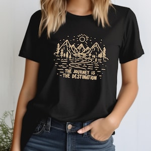 May include: Black t-shirt with a graphic of mountains, a river, and a sun. The text "The Journey is the Destination" is printed below the graphic.