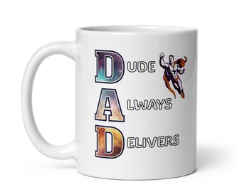 Op de afbeelding: Witte keramische mok met de tekst "DUDE DAD ALWAYS DELIVERS" in een kleurrijk, kosmisch lettertype. Een superheldenafbeelding staat aan de rechterkant van de mok. De mok heeft een gebogen handvat.