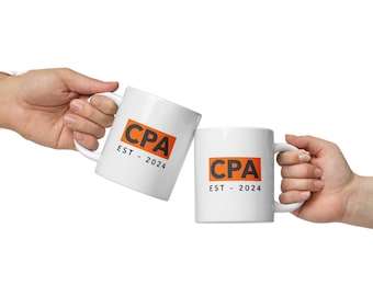 May include: Two white ceramic mugs with black handles. Both mugs feature an orange square with the text "CPA EST - 2024" in black.