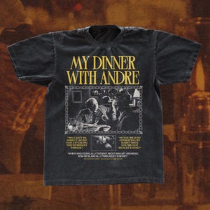 May include: Black t-shirt with a vintage-style graphic of two men sitting at a table. The graphic includes the text "My Dinner With Andre" and quotes from the film.