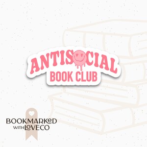 Könnte beinhalten: Rosa-weißer Aufkleber mit dem Text "Antisocial Book Club" in einer Retro-Schrift. Ein rosa Smiley mit Herzen als Augen tropft über dem Text.