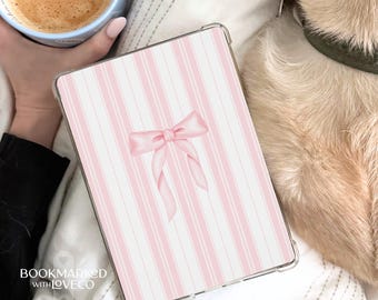 Op de afbeelding: Een tablet hoesje met een roze en witte streepjespatroon en een roze strik ontwerp. De hoes heeft een transparante rand. De afbeelding toont ook een kopje koffie en een hond.