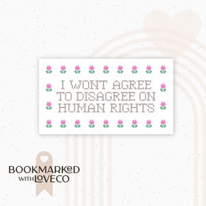 May include: A white card with the text "I WON'T AGREE TO DISAGREE ON HUMAN RIGHTS" in a cross-stitch style. The card is decorated with pink and green floral accents. The logo "BOOKMARKED WITH LOVECO" is at the bottom.
