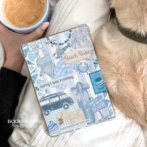 Könnte beinhalten: Eine blaue und weiße gemusterte iPad-Hülle mit verschiedenen Aufklebern, darunter ein blaues und weißes Streifenmuster, ein blaues und weißes Gingham-Muster, ein blaues und weißes Muschelmuster, ein blaues und weißes Krabbenmuster, ein blaues und weißes Surfboard-Muster, ein blaues und weißes Van-Muster, ein blaues und weißes Cupcake-Muster, ein blaues und weißes Strand-Schild-Muster und ein blaues und weißes Textmuster, das "Beach Babe" und "sorry I was reading" sagt.