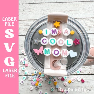 May include: A clear tumbler lid with a white background and a pink accent. The lid has a straw hole and is decorated with colorful letters spelling "I'M A COOL MOM" and various embellishments, including stars, a butterfly, and hearts.