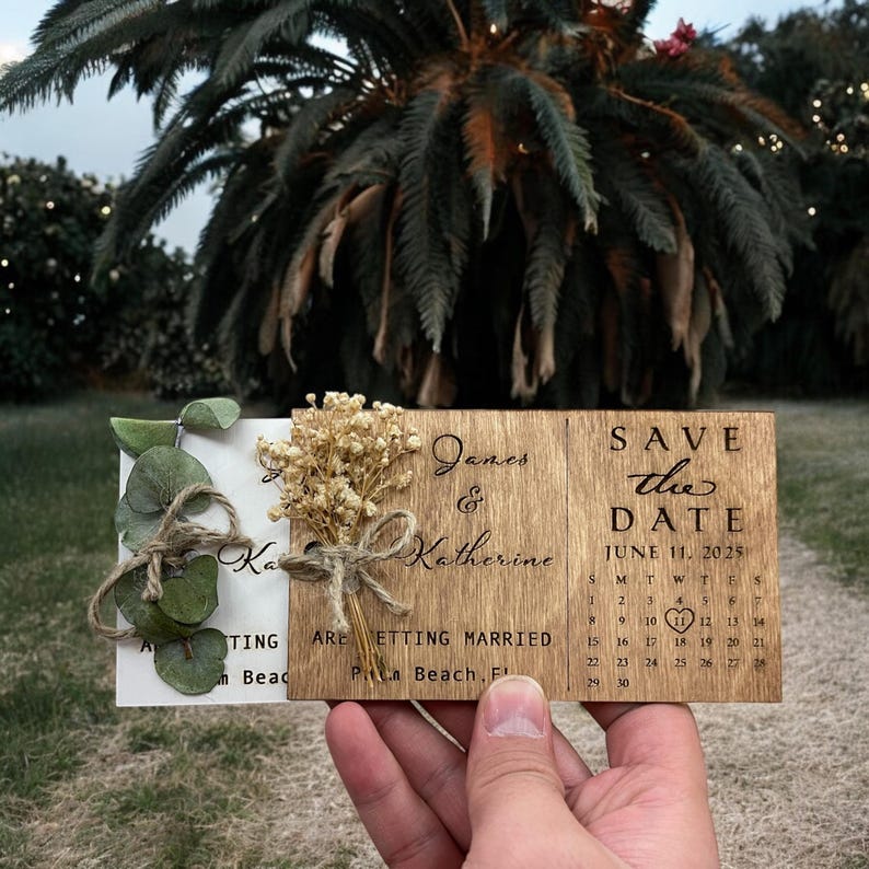 May include: A wooden save the date card with a calendar showing June 11, 2025, with a heart marking the date. The card also says "Save the Date" and "James & Katherine are getting married, Palm Beach, FL".