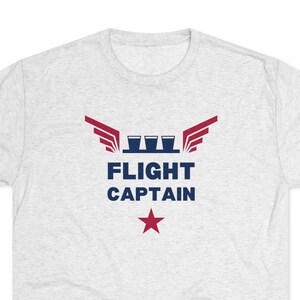 May include: A heather grey t-shirt with a blue and red graphic of wings, four shot glasses, and the text "FLIGHT CAPTAIN" with a red star below.
