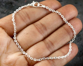 Puede incluir: Un brazalete de cadena de plata con cierre de langosta.