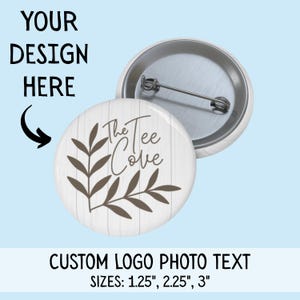 May include: A white button with a woodgrain pattern and a brown leaf design. The text "The Tee Cove" is printed on the button. The button is available in sizes 1.25 inches, 2.25 inches, and 3 inches.