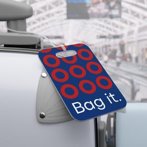 May include: Blue luggage tag with red donut pattern and the text "Bag it."
