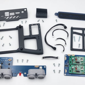 May include: A set of black and blue electronic components for a gaming console. The set includes a circuit board with the text "PC84-200 V.0", a circuit board with the text "PC84-233", a black plastic frame, a black plastic panel with the text "Aero Controller Tech", and several screws.