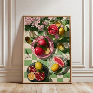 Puede incluir: Una impresión enmarcada que presenta una naturaleza muerta de frutas en platos. La imagen muestra granadas, limones y pomelos, dispuestos en platos sobre un fondo a cuadros verdes y blancos. Vasos de líquido y flores rosas completan la composición.